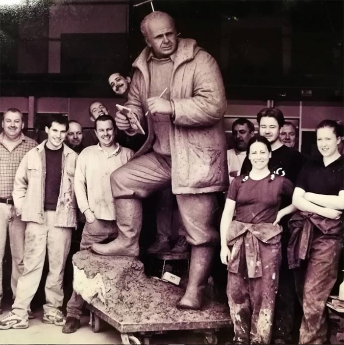 black and white photo of statue of Sire Peter Scott by artist Nicola Godden surrounded by workers from Talos Art Foundry in overalls